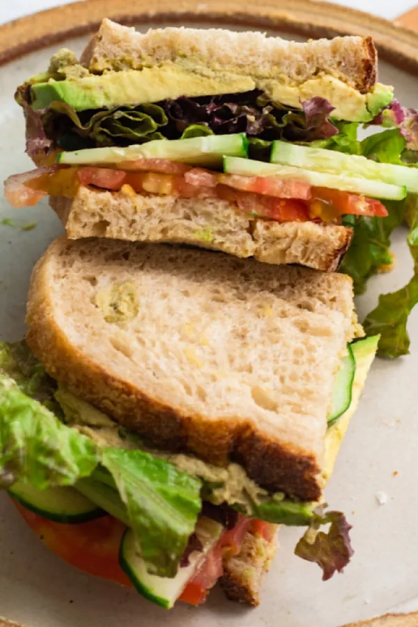 loaded vegan sandwich with hummus and cucumber